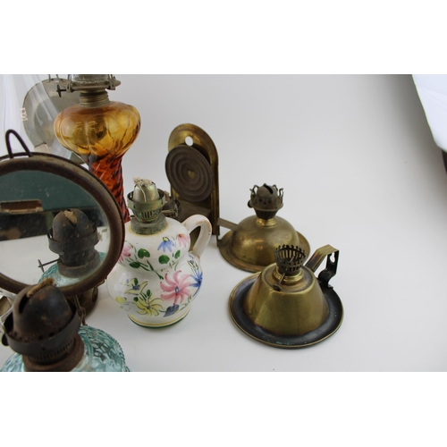 460 - A mixed collection of vintage and antique tin, pottery and brass oil lamps with glass chimneys and p... 