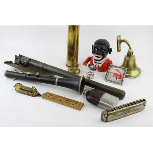 68 - A mixed collection of items to include replica Jolly Boy money box, military spade, shell casing and... 