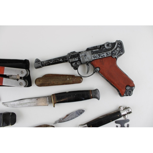 87 - A mixed collection of items to include a collection of vintage pocket knives and a Luger cap gun. (Q... 