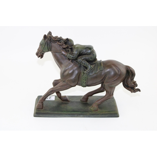 25 - A bronzed figure of a horse and jockey in seated pose cast in resin. Height 23cm.