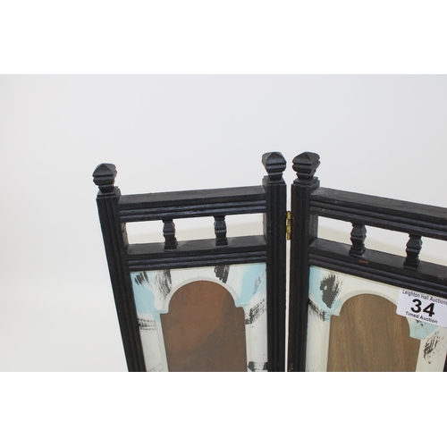 34 - A folding picture frame with Arabesque style window design surrounds. Height 29.5cm.