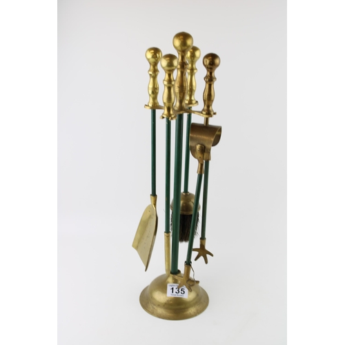 135 - A fireside campanion set in brass. Height 49cm.