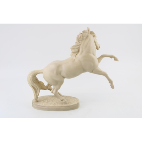 197 - A marble style figure of a horse prancing, cast in resin. Height 29cm.