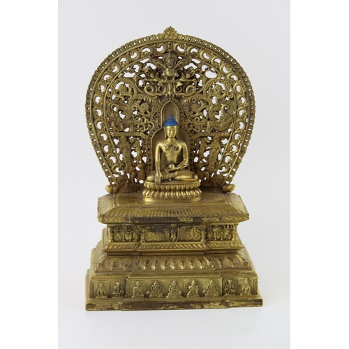 203 - Reproduction Tibetan gilded figure of a seated Buddha, on stepped throne, 28cm tall.