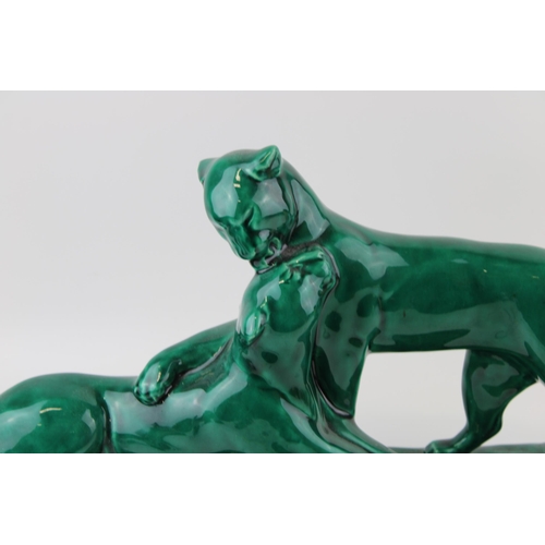 148 - 20th century French Art Deco green glazed figure of two lions, 52cm long.