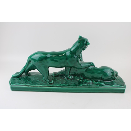 148 - 20th century French Art Deco green glazed figure of two lions, 52cm long.