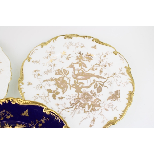 266 - A trio of Coalport plates with heavy gilded decoration of birds and foliage, two with white ground a... 