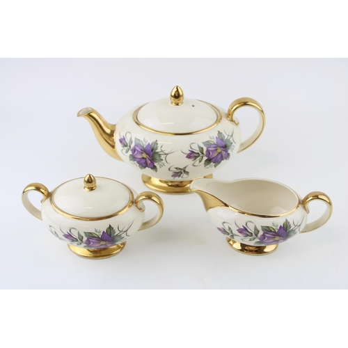 296 - Sadler purple flower tea set to include a teapot, lidded sugar and milk jug (3).