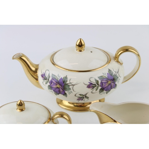 296 - Sadler purple flower tea set to include a teapot, lidded sugar and milk jug (3).