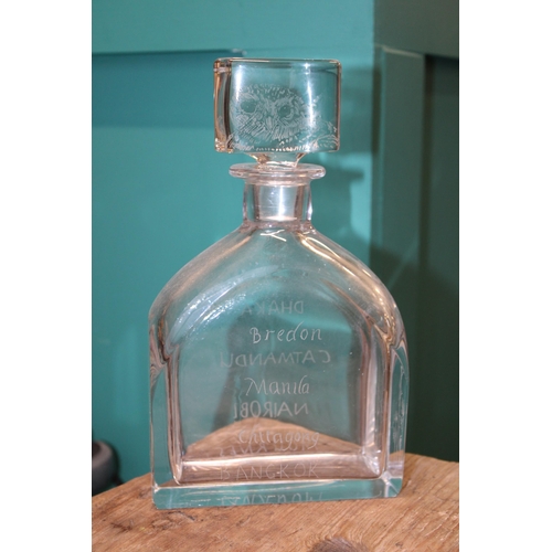 369 - Leslie Smyth glassware decanter with various place names engraved, 23.5cm tall.