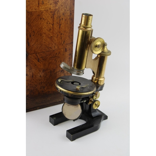 387 - An early c20th brass & steel microscope possibly by Wray, London with spare lenses in the original w... 