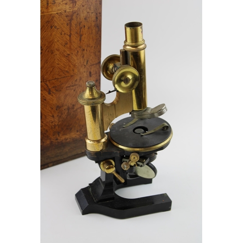 387 - An early c20th brass & steel microscope possibly by Wray, London with spare lenses in the original w... 