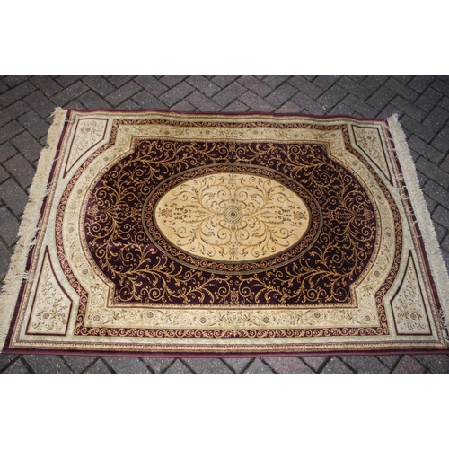 393 - A Persian style carpet in crimsons and creams. Dimensions 175cm x 119cm.