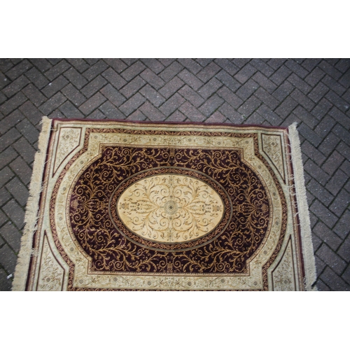 393 - A Persian style carpet in crimsons and creams. Dimensions 175cm x 119cm.