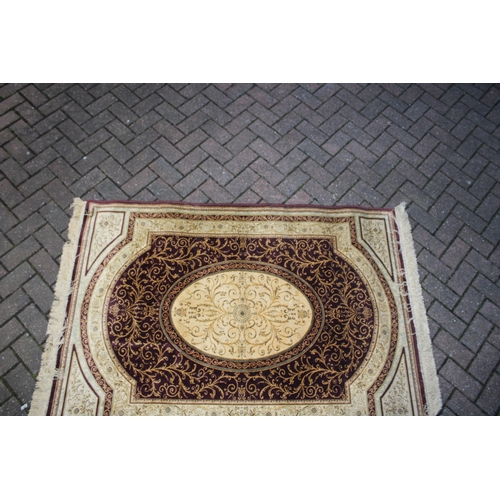 393 - A Persian style carpet in crimsons and creams. Dimensions 175cm x 119cm.