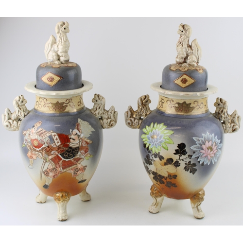 397 - A pair of Early 20th century Satsuma vases Fu Dog finials to lid, ornate handles, raised on three le... 