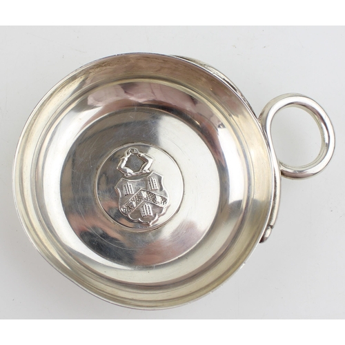 568 - Sterling silver wine taster hallmarked London 1948 with family crest decoration. Weight 63.5g.