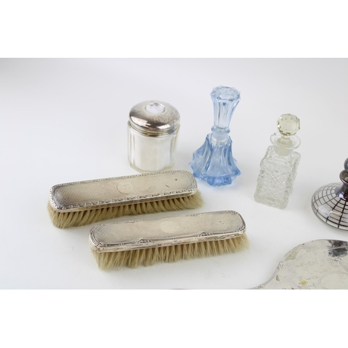 580 - A group of silver dressing table items, comprising three silver backed clothes brushes, and two silv... 