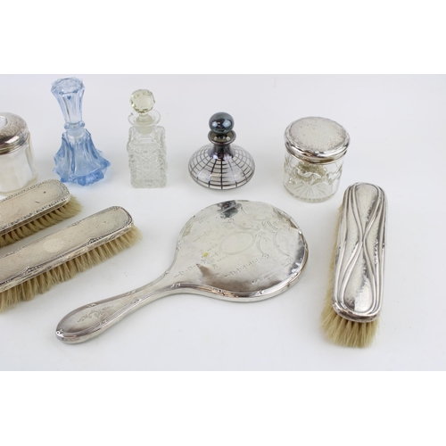 580 - A group of silver dressing table items, comprising three silver backed clothes brushes, and two silv... 