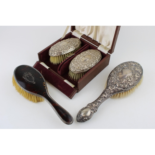 593 - A collection of silver brushes to include two matching examples in box, a silver pique tortoiseshell... 