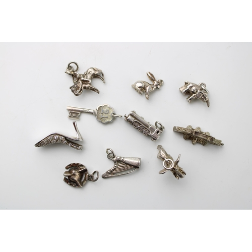 599 - A collection of 10 assorted silver charms to include a harp, a train and others (10).