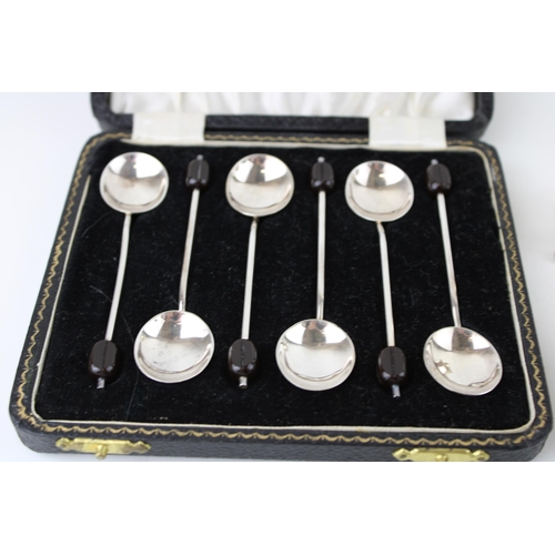 279 - A set of six silver coffee spoons with coffee bean finials, and a cruet set comprising salt and pepp... 