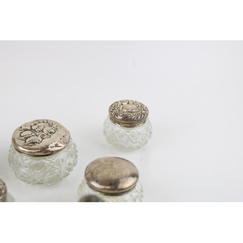 315 - A collection of silver topped glass jars and similar to include a perfume bottle, toilet jars, an op... 