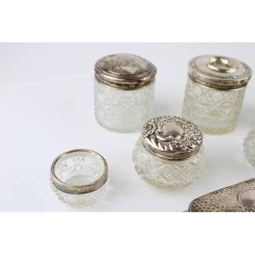 315 - A collection of silver topped glass jars and similar to include a perfume bottle, toilet jars, an op... 