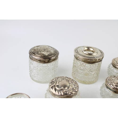 315 - A collection of silver topped glass jars and similar to include a perfume bottle, toilet jars, an op... 