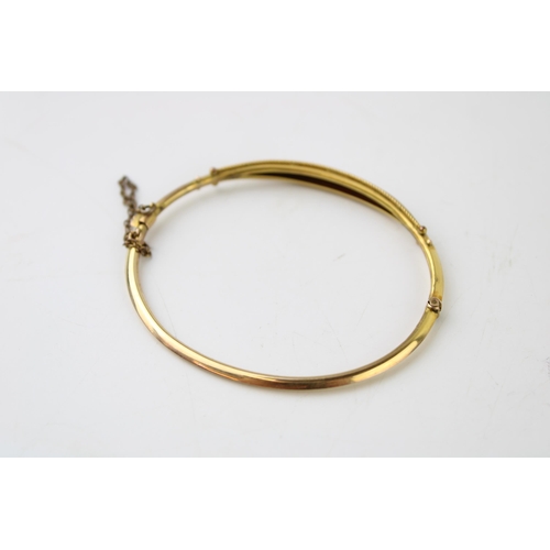 323 - A yellow metal lady's bangle, tests as 9ct or better, set graduated seed pearls, in period fitted bo... 