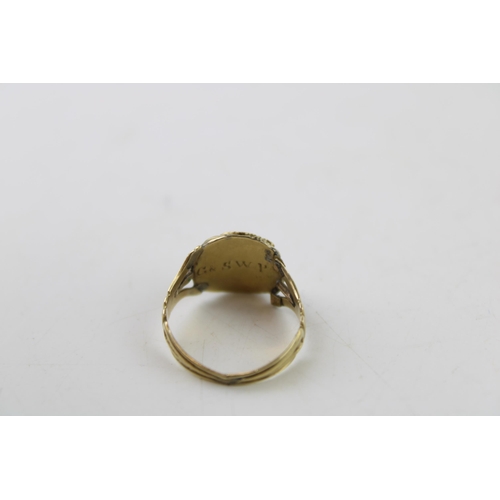 345 - A 19th century mourning ring, tests as 9ct gold or better, inset with a garnet and monogram engraved... 