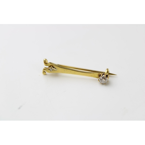 348 - An 18ct gold brooch in the form of a stylised Eiffel tower, set with an old cut diamond to the top, ... 