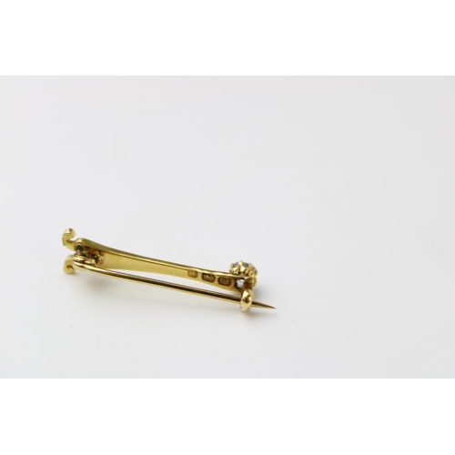 348 - An 18ct gold brooch in the form of a stylised Eiffel tower, set with an old cut diamond to the top, ... 