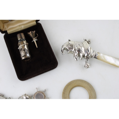 351 - A group of silver comprising a silver cased small scent bottle and funnel, a silver charm bracelet w... 