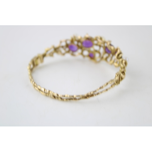 352 - A 9ct gold amethyst and pearl bangle set with five amethysts and four pearls in an organic scrolling... 