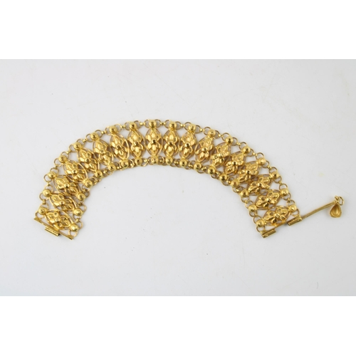 367 - An Indian gold bracelet, with eighteen panels each with faceted flower detail, with pin clasp, unmar... 