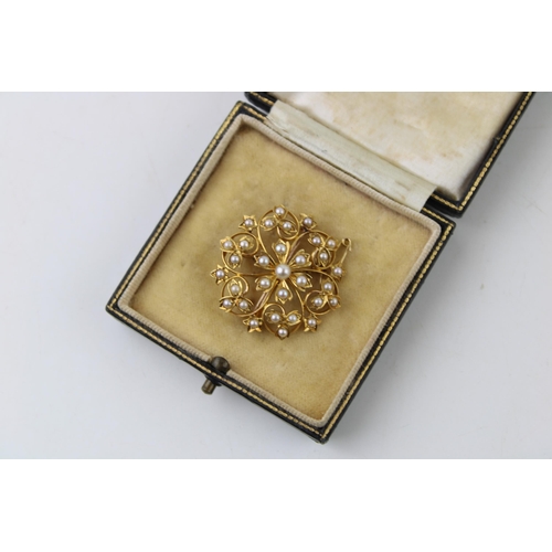 369 - Yellow metal (tests as 15ct gold) floral brooch, set seed pearls, with safety chain, 5.9g, in period... 