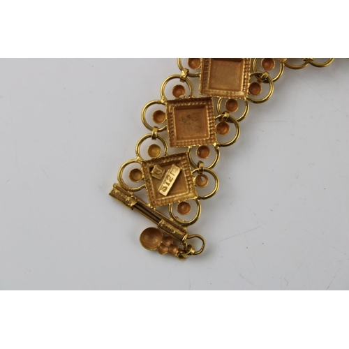 377 - Yellow metal (XRF tests as 18ct gold or better) bracelet, fancy links, enamelled coloured decoration... 