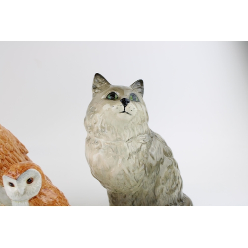 187 - A Beswick Cat together with three Beswick Barn Owls. (4) Height 21cm.