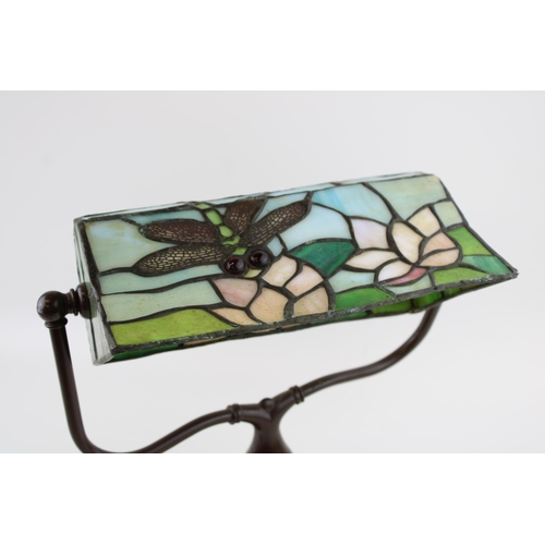 287 - A Tiffany style / stained glass banker's lamp with dragonfly design on cast metal base. Height 33cm.