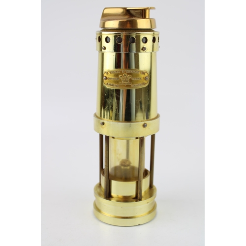 336 - Novelty brass effect table lighter in the form of a miner's lamp, 22cm tall.