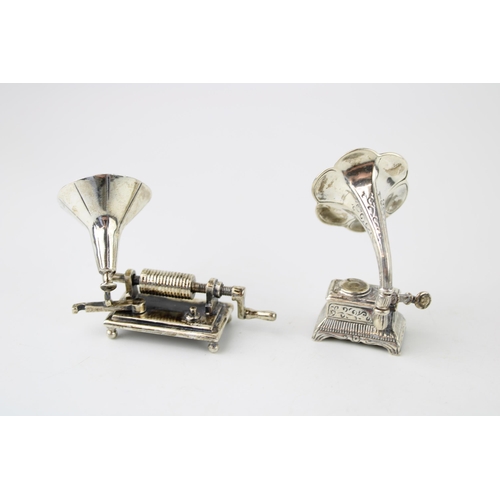 357 - A collection of silver jewellers toys in the form of gramophones. (2) 58g.