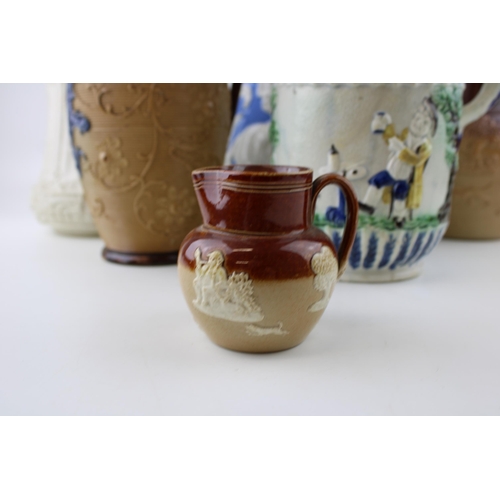 104 - A collection of 19th century pottery jugs to include salt glazed relief pitchers by Doulton, Prattwa... 