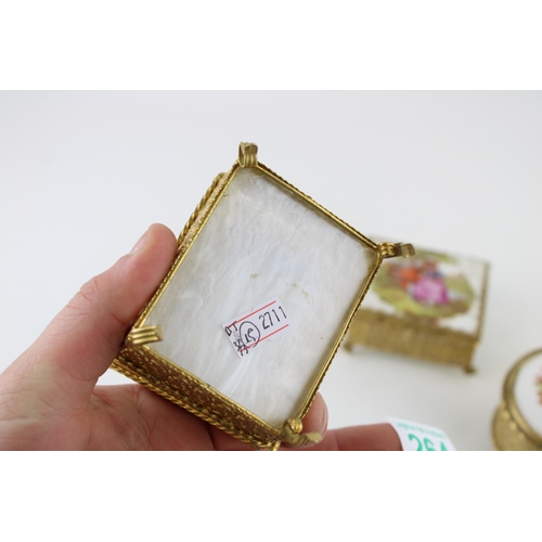 264 - Three vintage jewellery boxes with gilt metal frames and ceramic lids. Height 6cm. (3)