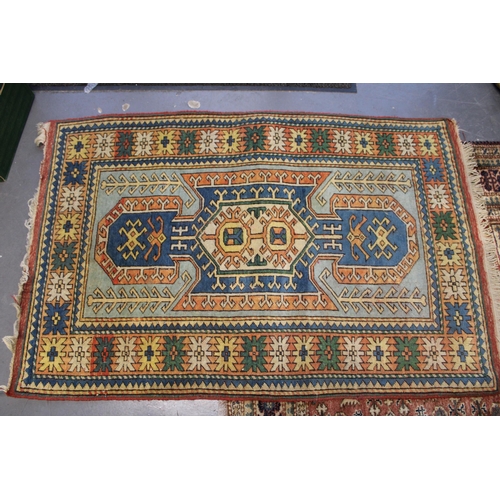 284 - A Turkish hand knotted carpet in pale blue, blue, oranges and reds. 104cm x 162cm