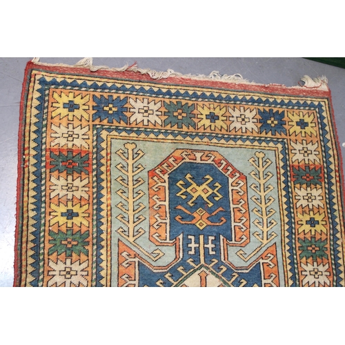 284 - A Turkish hand knotted carpet in pale blue, blue, oranges and reds. 104cm x 162cm