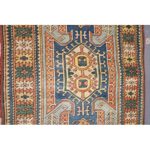 284 - A Turkish hand knotted carpet in pale blue, blue, oranges and reds. 104cm x 162cm