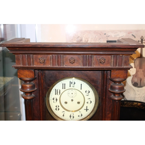 290 - A Vienna wall clock. Ceramic dial with brass pendulum. Height 91cm.