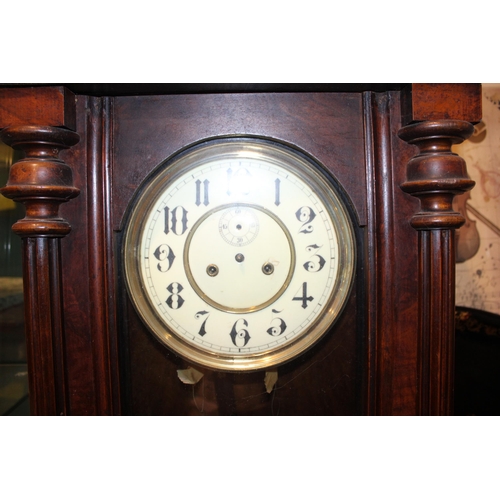 290 - A Vienna wall clock. Ceramic dial with brass pendulum. Height 91cm.