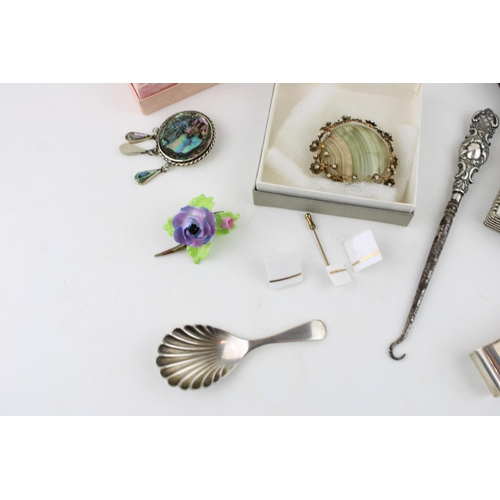 358 - A collection of Silver hallmarked items including a pair of candlesticks, button hook, a caddy spoon... 